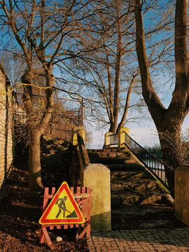 Stairs with construction warning sign near a river