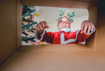 Child in Santa Outfit Sharing Festive Joy Open Present Gift Box, Happy Kid Opening Giftbox in Xmas Tree Home Interior