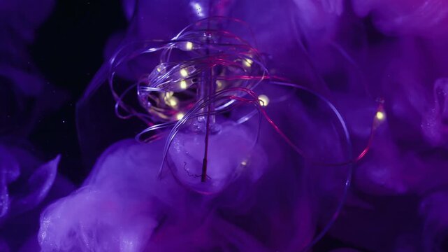 Blur vapor splash. Neon light bulb. Purple violet shiny fluid exploding in broken glass. Garland fume paint color abstract black background.