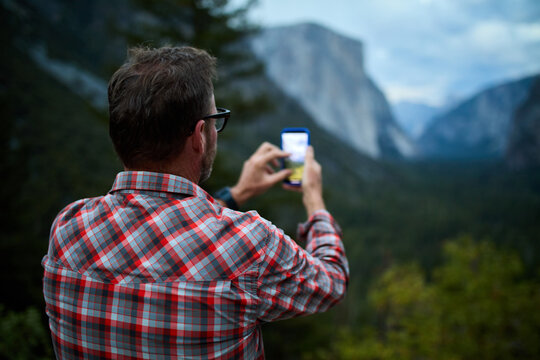 Man captures images of a mountain scene