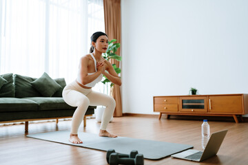 Young Asian beautiful woman doing aerobic exercise at home. Attractive girl doing  workout by...