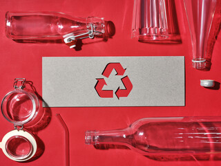 Recycling concept with glass bottles, jars, and a recycling symbol