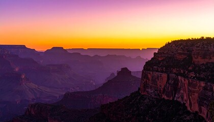 Fototapeta premium Grand Canyon at sunrise displaying layers of rock formations and colorful sky
