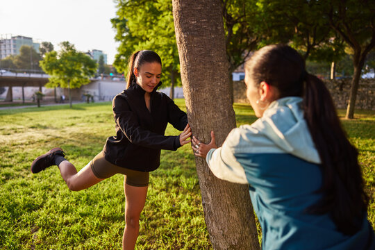 Friends stretching together in a sunny park in the evening