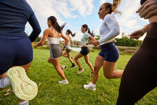 Group of women running together in a park during daytime