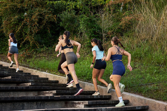 Women exercising while running up outdoor stairs in a park