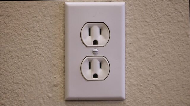 Slow Motion Close-Up of Unplugging Electrical Plug from Wall Socket