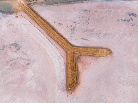 Y sahped walkway out onto a pink salt lake