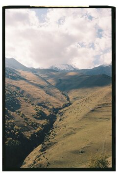 Mountain landscape with rolling hills and snow-capped peaks