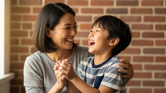 A mother and her son share a joyous moment, laughing together with their arms around each other