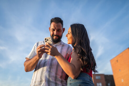 Young couple using smartphone with blue sky background