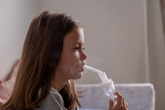 Child inhales and breathes through a nebulizer tube.