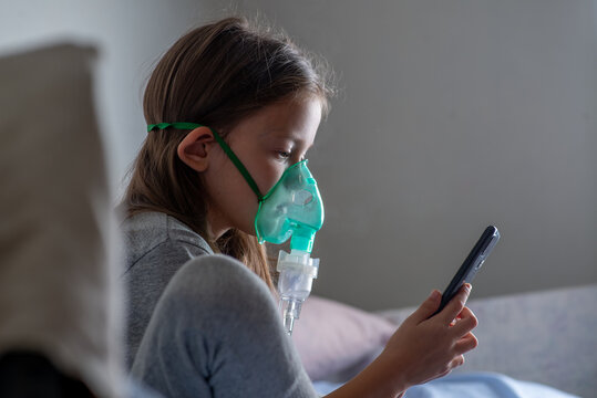 Child with a nibulaise mask inhales. Steam of the medicine