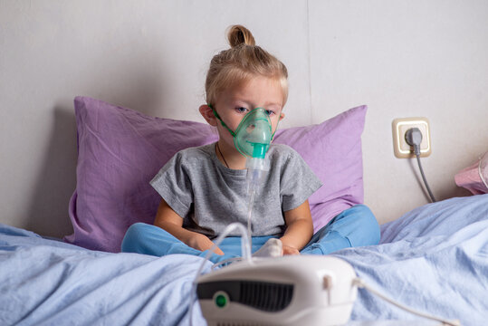 Child with a nibulaise mask inhales.