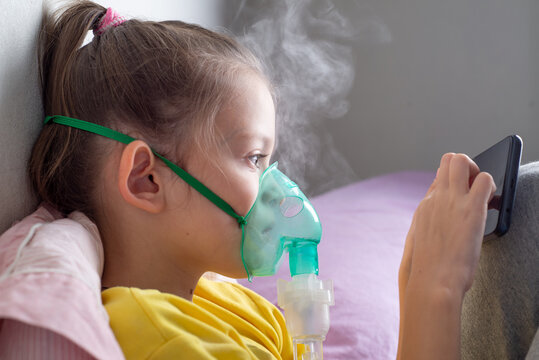 Child with a nibulaise mask inhales. Steam of the medicine