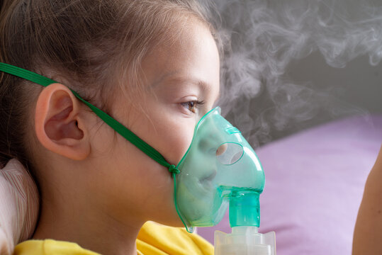Child with a nibulaise mask inhales. Steam of the medicine