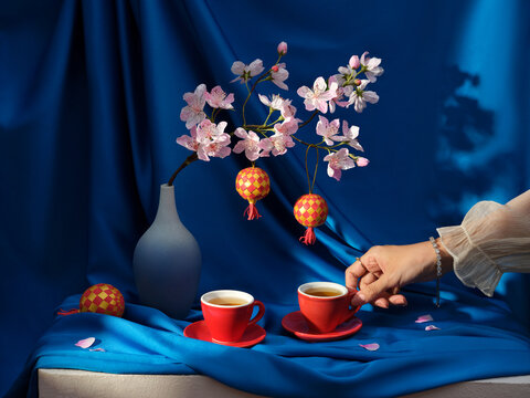 Beautiful cherry blossoms and tea cups are placed artfully