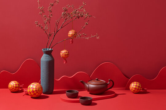 A beautifully composed still life, featuring a teapot, cups on red
