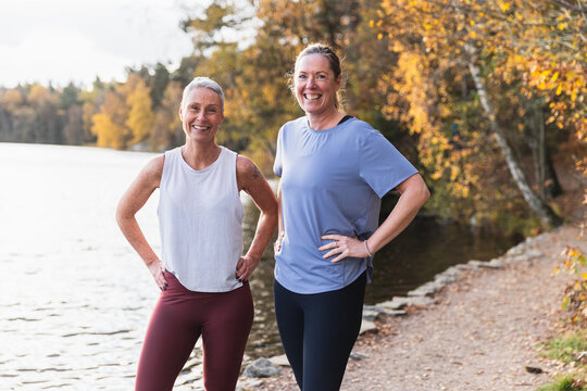 Happy Friends in Activewear Posing by Autumn Lake