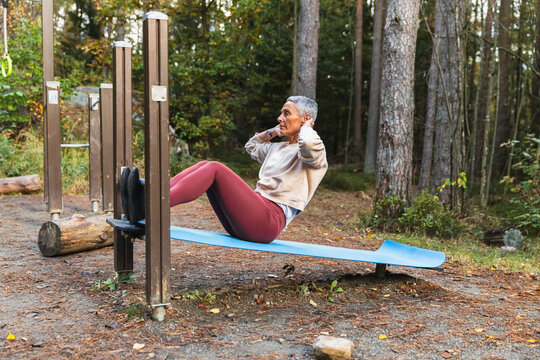 Woman Doing Sit-ups at an Outdoor Forest Gym