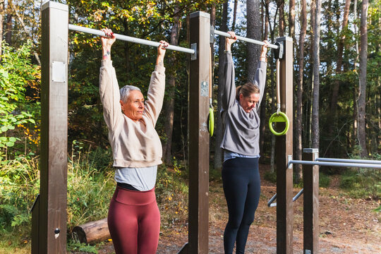 Two Friends Hanging from a Pull-up Bar at an Outdoor Gym