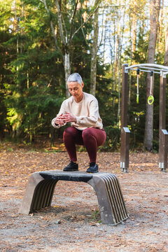 Woman Performing Box Jump at Outdoor Forest Gym