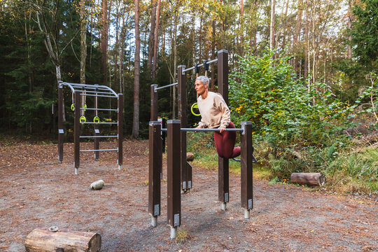 Woman Using Outdoor Gym Equipment in a Forest