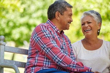 Love, laughing or senior couple on park bench for bonding, trust or connection in funny joke. Retirement, space or elderly people outdoor together on weekend, comic conversation or happy relationship