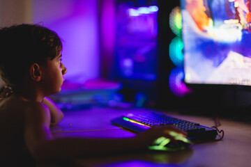 Young gamer immersed in colorful screen light during evening gaming 