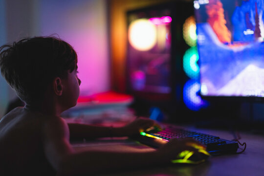 Young gamer immersed in a colorful world during a late-night gaming se