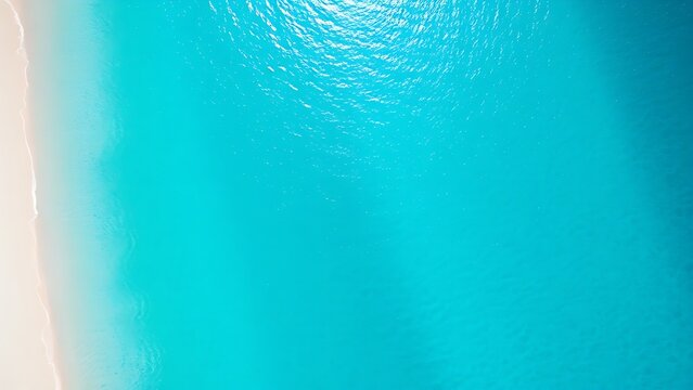 Aerial view of turquoise coastal waters with white sand, capturing the beauty of a tropical paradise.