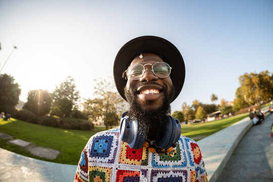 Happy beaming man smiling at park on sunny day
