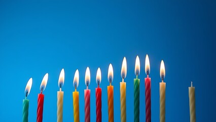 Vibrant candles glowing against a blue backdrop, creating a festive and celebratory atmosphere.