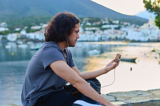 Man using smartphone by the sea in Cadaqu&eacute;s Spain