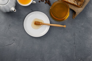 Honey background. Sweet honey in the glass jar. Light gray background. Copy space of your text.