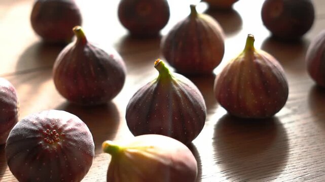 Close-up of ripe figs on wooden surface with soft lighting. Food concept, healthy lifestyle.