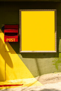 Frame with copy space on a yellow wall and a red mailbox in sunny spot
