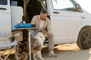 Man bonding with dog while camping