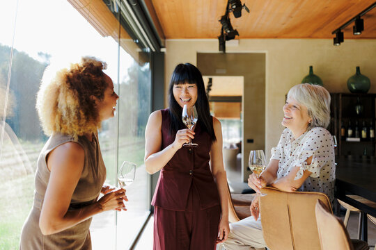 Diverse women friends enjoying wine tasting at winery