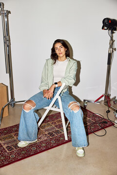 Woman posing confidently in casual outfit and minimalistic studi