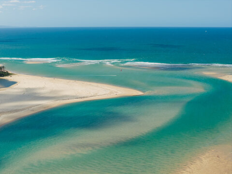 Channels of turquoise water running around sand bars out to sea