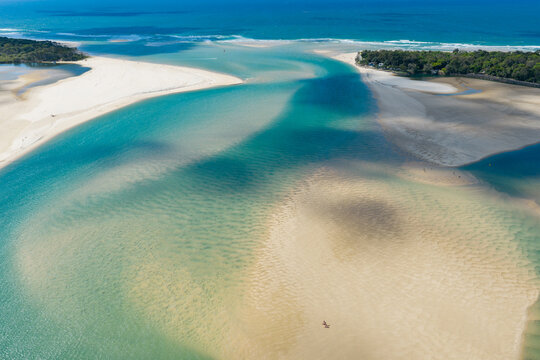 Channels of turquoise water running around sand bars out to sea