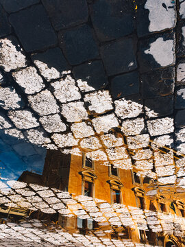 Historic architecture reflected in puddle