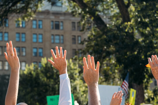 Hands in the Air Together at Political Protest Rally 
