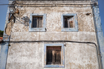 Old weathered building with blue window frames and peeling walls