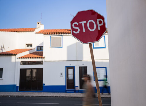 Stop sign on street in front of traditional Mediterranean houses