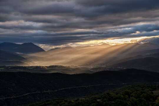 Sun rays shining over a mountain valley