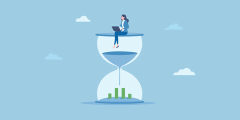 Businesswoman working on laptop on top of hourglass with financial chart below