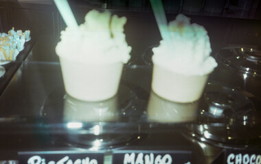 Close-up image of two cups of ice cream in an ice cream parlor.