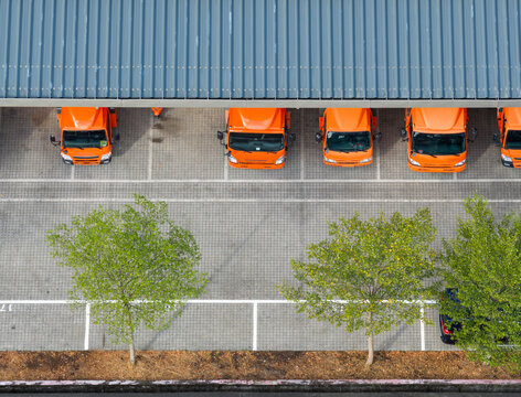 Aerial View of Orange Delivery Fleet at Warehouse
